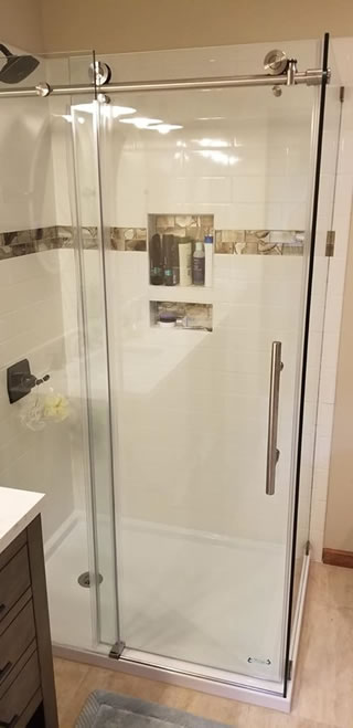 Walk-in shower with a glass enclosure and beautiful tile surround.